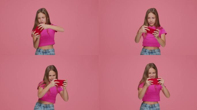赌博小女孩Z世代游戏玩家孩子在粉红色工作室背景下的手机上玩在线虚拟游戏。小玩意成瘾