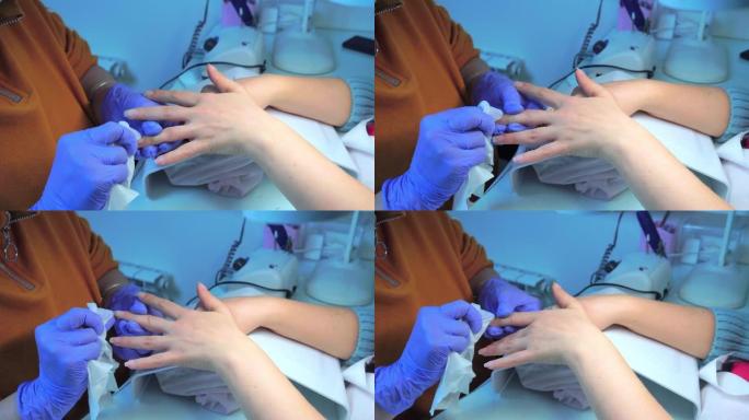 戴着蓝色手套的修指甲大师的手使用电动指甲锉去除角质层