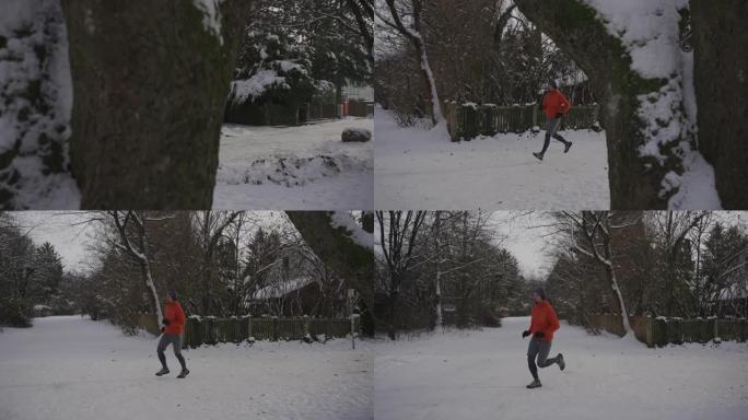 德国冬天，男人在白雪皑皑的小路上慢跑穿过城市的公园，戴着耳机听音乐。运动员在寒冷的天气里戴着耳机锻炼
