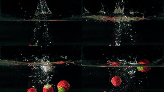 黑色背景上草莓落水的特写镜头。