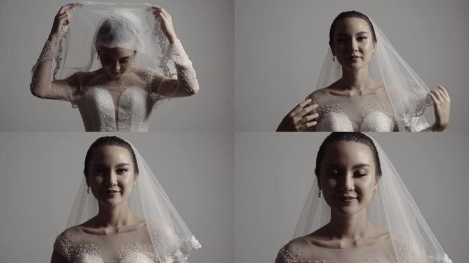 肖像美丽的新娘打开面纱在她的脸。婚礼准备。