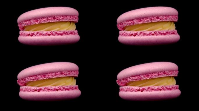 黑色背景上旋转的粉红色马卡龙。食品概念。糖果在转盘上关闭