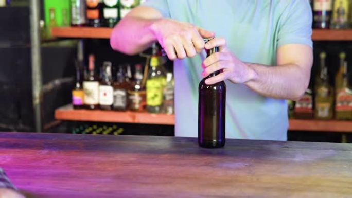 酒保在现代酒吧的内部开了两瓶啤酒。在酒吧为顾客服务