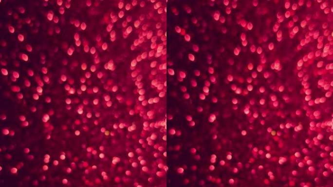 Bokeh垂直背景充满活力的红宝石红色粉色深品红色和颜色。在黑暗的背上改变微小的圆圈。节日情人节概念