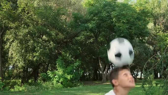 十几岁的男孩用头弹跳球。足球技巧训练。