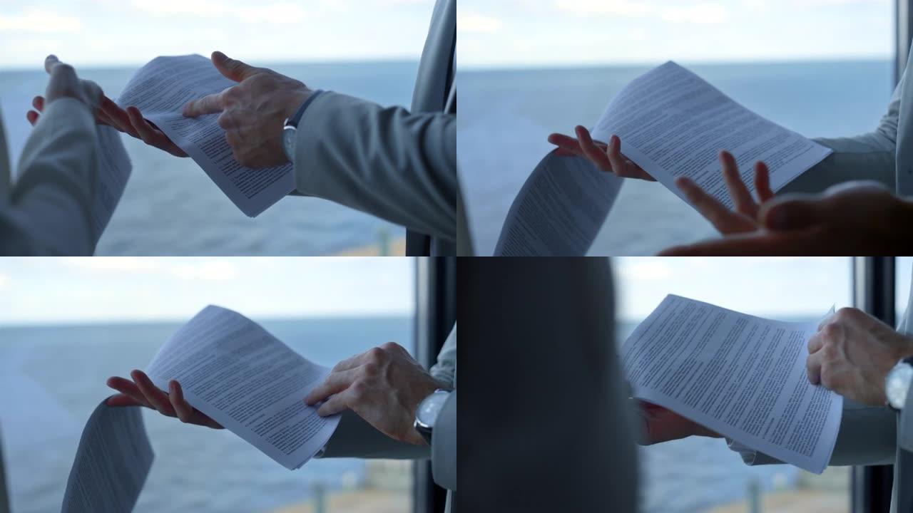 男子在海景展示合同细节。手握指向文件特写