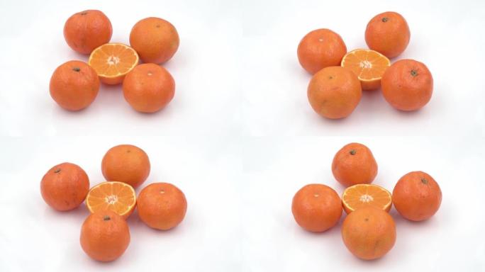 白色盘子上的新鲜湿橘子旋转背景。顶视图