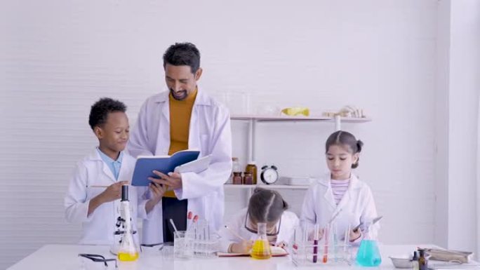 4K，科学老师，在教室里走来走去，谁教和给学生，学习化学实验，老师敬佩地站着，给男学生做笔记，在科学
