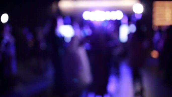婚礼派对。客人腿和新婚夫妇的剪辑视频在宴会厅的舞池中模糊地跳舞很有趣，投影仪闪烁着五颜六色的灯光。模