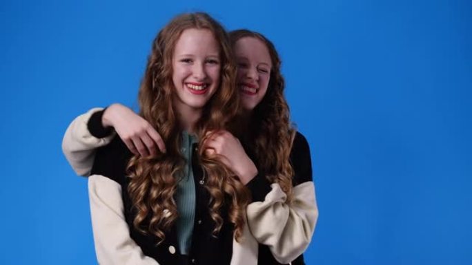 两个双胞胎女孩微笑着看着相机的4k慢动作视频。