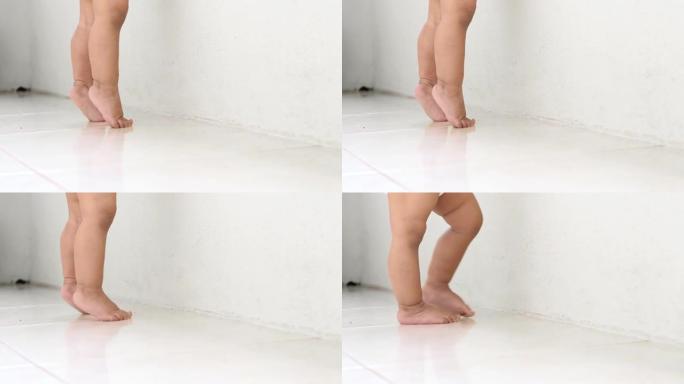 一个女婴的脚特写，踮起脚尖，白色背景。学习走路。