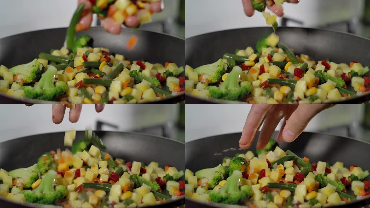 油炸有机蔬菜。将五颜六色的热气腾腾的蔬菜放在锅上混合。烹饪过程，健康食品，素食。慢动作。素食有机保健