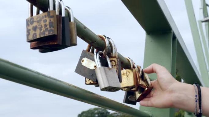 女人在桥梁的铁栏杆上研究金属挂锁，与爱情相连54