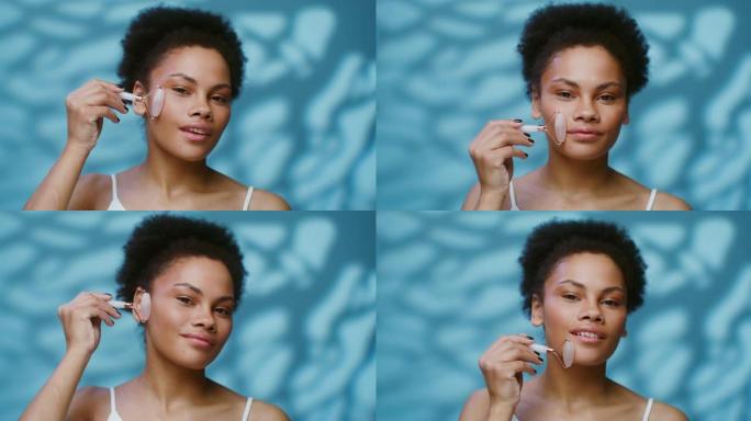 一名年轻的非洲裔美国妇女使用刮痧进行面部按摩