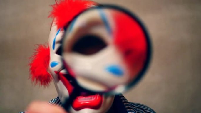 小丑透过放大镜看。