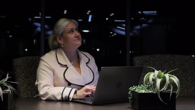 停电期间的成年女商人上班族在一个暴风雨的下雨的夜晚在笔记本电脑上工作4k视频系列