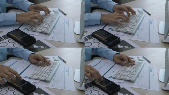忙碌的商人使用笔记本电脑和计算器来准备预测的预算。