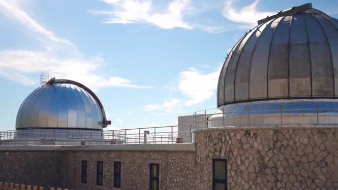 带有金属圆顶的科学天文台大楼，用于外层空间研究和大气监测，位于山脚下的天文馆站传输重要的科学信息数据