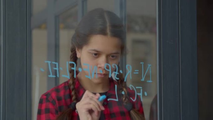聪明的少年在玻璃上写外星文明的数字方程式