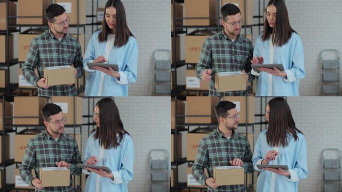 一位使用平板电脑的女性销售经理正在与一位拿着纸板包装的男性工人交谈。后台准备装运包裹的仓库。