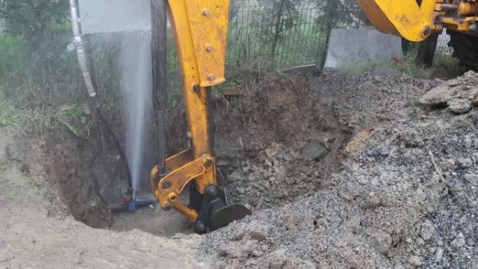 用加料器打开从爆裂水管流出的水和土壤