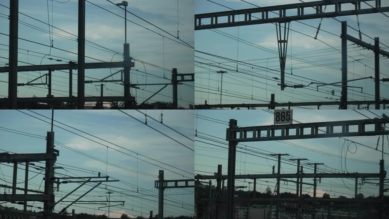从行驶中的火车内的乘客窗口看到许多电线和电线杆。现代金属景观