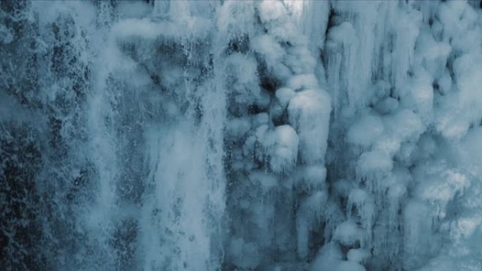 冬天结冰的悬崖上落水的特写。冰冻瀑布景观
