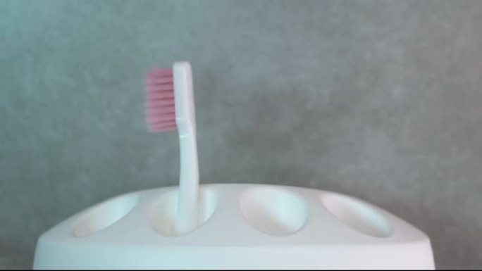 一个男人从一个白色的箱子里拿了一把白色的牙刷。牙科保健。健康牙齿概念。在浴室刷牙