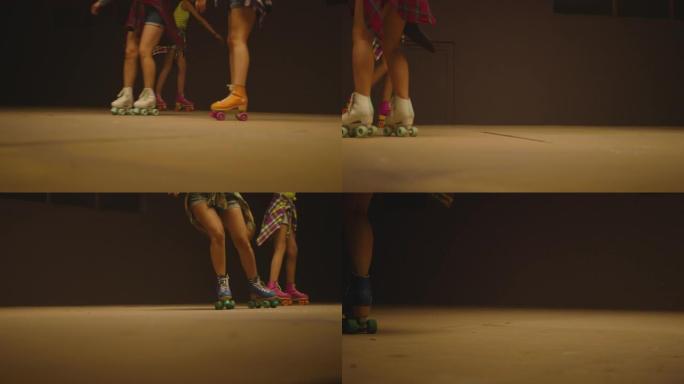 穿着旱冰鞋的女性腿，在地板上的旱冰鞋公园快速滑冰。年轻女性的特写腿是专业滑冰。不同种类的彩色老式滚筒