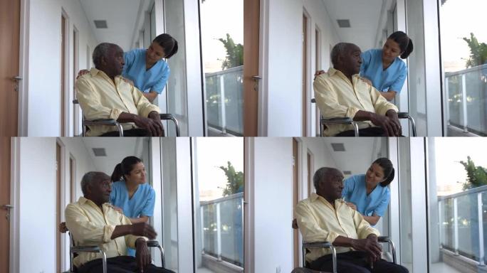 有爱心的护士试图在辅助生活设施的轮椅上安慰黑人高级患者