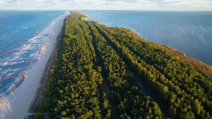 在沿着沙滩和波兰蓝色波罗的海的阳光照射下，在Zatoka Pucka的绿色长岛上空进行空中向后飞行
