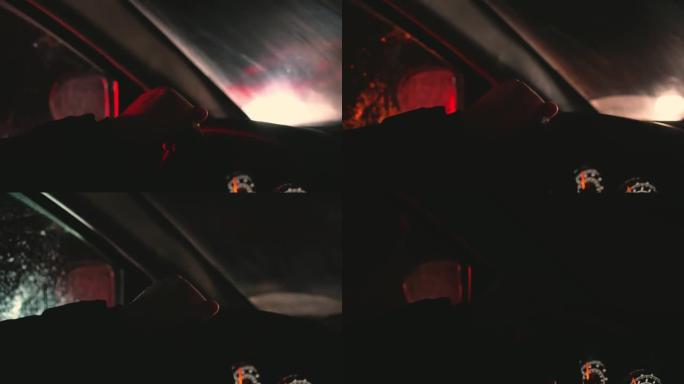 夜间道路背景和快速通过的汽车眩光背景下的男子驾驶员手在方向盘上
