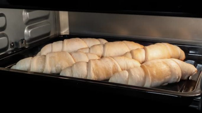 延时-六个自制羊角面包在家里的电烤箱中烘烤和上升