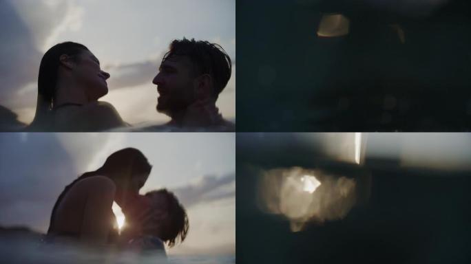 浪漫的异性恋夫妇在美丽的金色日落时在海里游泳。在水中玩耍和拥抱