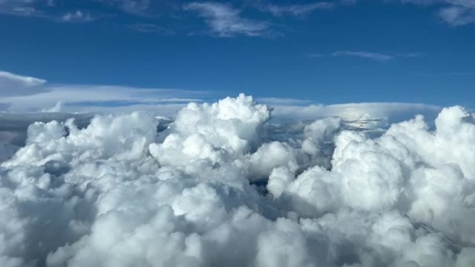 喷气式飞机驾驶舱飞越暴风雨的积雨云和深蓝色的天空，令人敬畏。试点观点。4K 60 FPS。