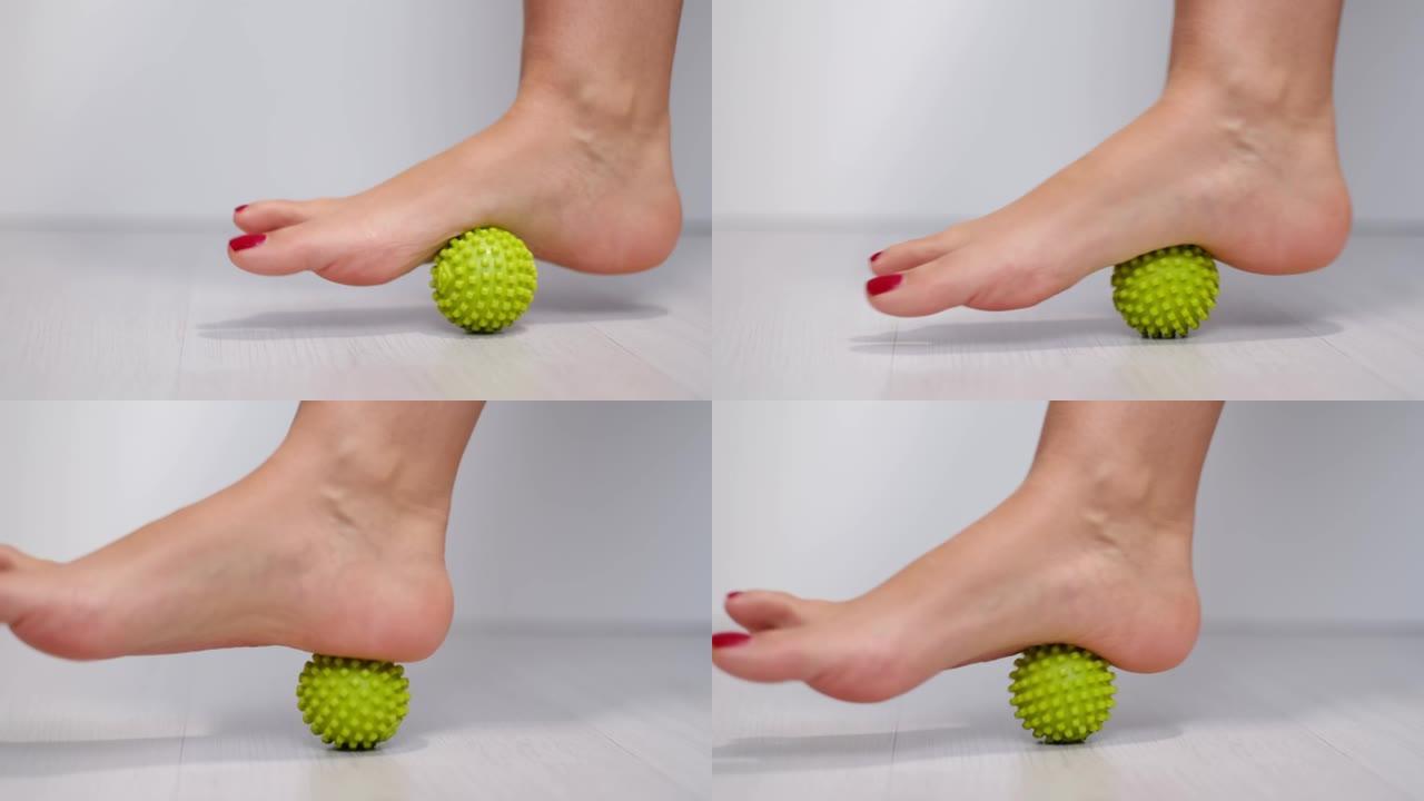 脚踩按摩球以缓解足底筋膜炎或脚跟疼痛。用红色修脚按摩脚触发点的女人