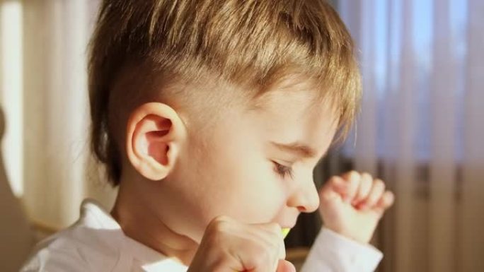 3岁的金发男孩蹒跚学步的孩子饭后在房间里用牙刷勤奋地刷牙。健康习惯。慢动作特写FHD