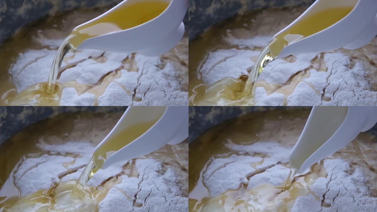 慢动作将葵花籽油倒入面团制作过程中。将葵花籽油添加到鸡蛋-糖混合物中特写，披萨面团制备