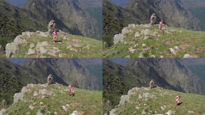 无人机鸟瞰图: 年轻健康的女性在阿尔卑斯山奔跑。女性在山脊上跑步，无人机