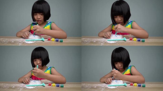 彩虹色连衣裙的中国女孩挖石膏洞寻宝