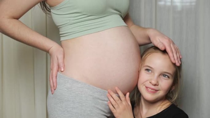 大女儿听着宝宝在妈妈怀孕的肚子里动