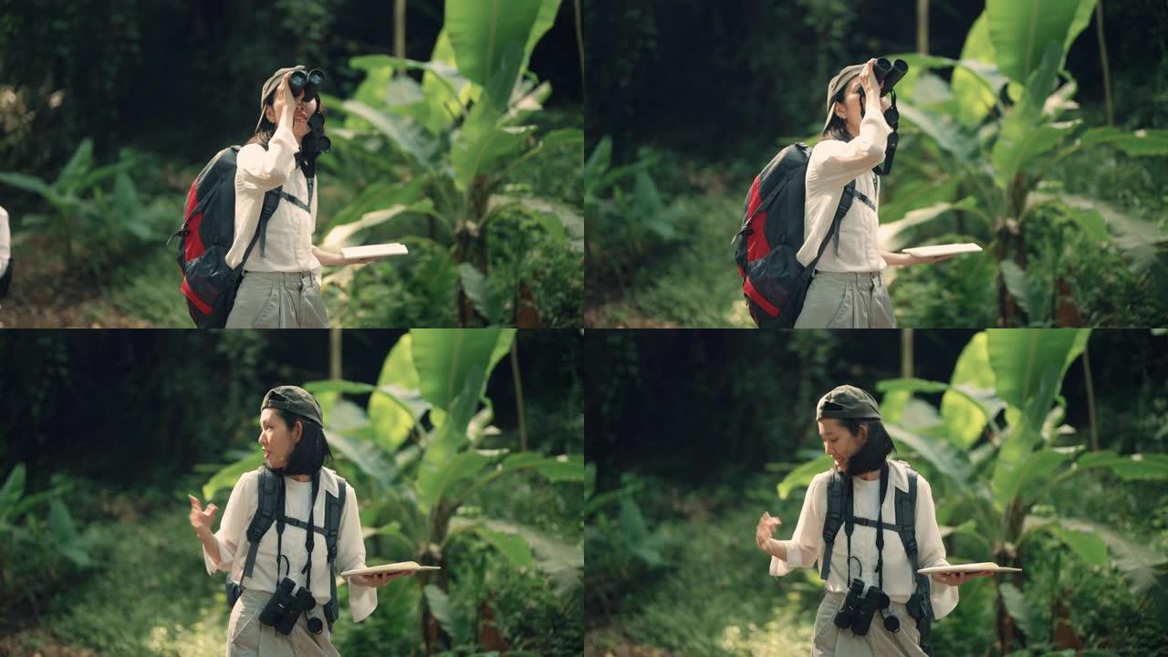亚洲妇女使用双筒望远镜在森林中寻找鸟类