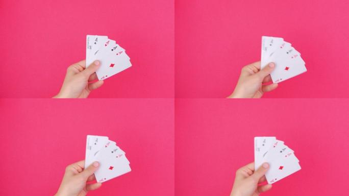 赌徒手中的五种扑克游戏卡掉落钞票粉红色背景。幸运组合ace和Joker揭示。在线赌博赌场游戏赢家成功