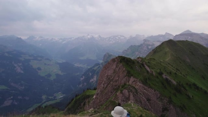 日落时沿着山脊线的徒步旅行者的空中无人机拍摄