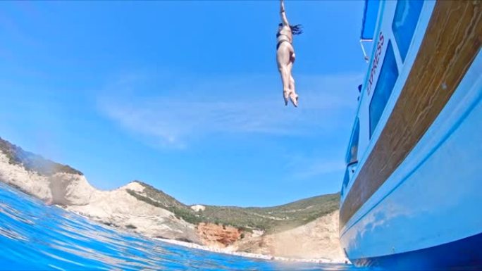 希腊莱夫卡达-2021年9月04日: 女人在清澈的海水中从船上跳下来