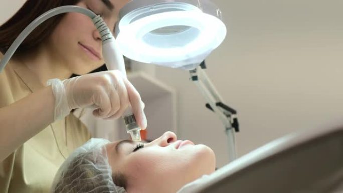 美容师用低频电流脉冲对面部进行治疗。