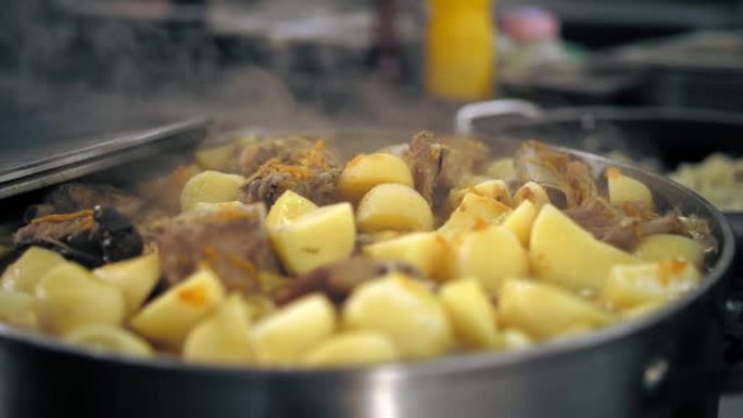 烹饪。炖肉。自助餐厅厨房。特写。食物在蒸，在锅里沸腾。在商用厨房中准备和烹饪食物