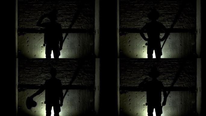 一个男人的剪影把帽子戴在头上，把双手放在臀部，靠在砖墙的背景上