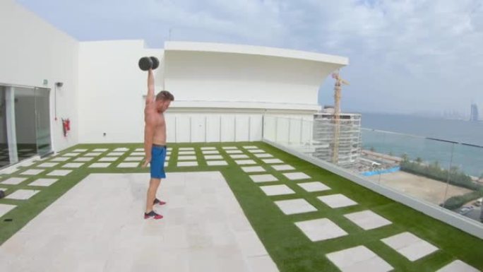 肌肉健美男子在迪拜一家酒店的屋顶上锻炼。