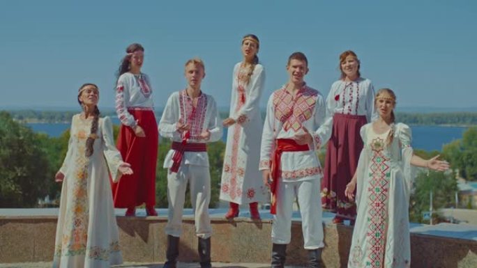 美丽的乌克兰男女在山上唱歌，他们穿着民族服装和刺绣服装。乌克兰人民享受生活，在公园里唱歌，幸福的生活
